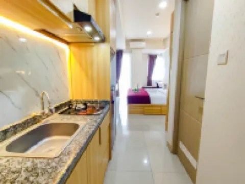 Wood Accents Studio at Grand Dharmahusada Lagoon Apartment by Travelio