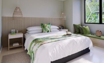 a modern bedroom with white walls , wooden ceiling , and a large window , featuring a bed with green bedding and pillows at Crystalbrook Byron