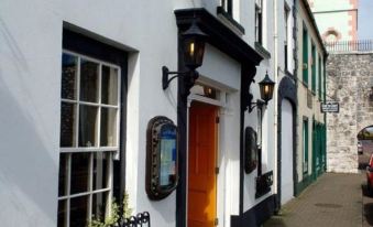 a brick building with a storefront on the side , one of which has a sign above it at Londonderry Arms Hotel