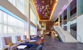 a modern , spacious hotel lobby with multiple couches , chairs , and a staircase leading to the second floor at InterContinental Hotels Minneapolis - ST. Paul Airport