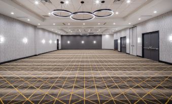 an empty conference room with a large , empty floor and multiple hanging lights , providing a sense of normality in the space at Holiday Inn Long Island - Islip Arpt East