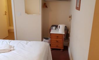 a hotel room with a bed , a tv , and a small kitchenette , all neatly arranged at The Westgate