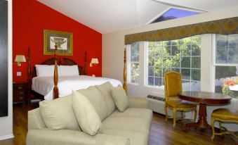 a modern living room with a large window , white walls , and a red accent wall at Malibu Country Inn