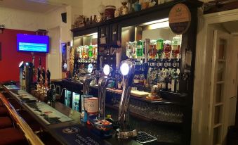 a bar with two beer taps and a variety of bottles on the counter , creating an inviting atmosphere for patrons at The Osborne