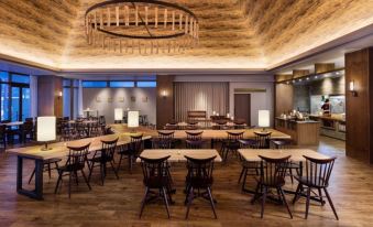 a large dining room with multiple tables and chairs arranged for a group of people to enjoy a meal together at Courtyard by Marriott Hakuba