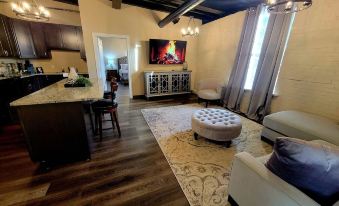 a cozy living room with hardwood floors , a fireplace , and a flat - screen tv mounted on the wall at The Inn at Stone Mill