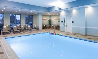 an indoor swimming pool with a clear blue water , surrounded by white walls and a ceiling with lights at Hampton Inn & Suites Chicago North Shore