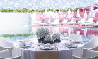 a well - decorated dining table set for a formal event , with multiple chairs surrounding it and a pool in the background at Semiramis Hotel