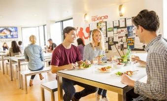 a group of people are sitting around a table in a restaurant , enjoying their meal and each other 's company at Space Hotel