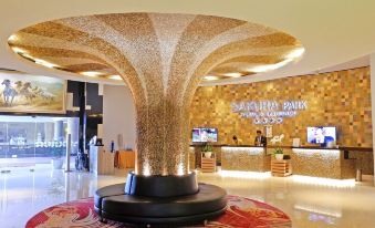 a hotel lobby with a large reception desk and a waterfall fountain in the center at Sakura Park Hotel & Residence