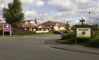 "a residential area with a group of houses , including houses with a sign reading "" hotel "" and a bridge over a road" at Premier Inn Pontefract North
