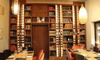 a well - lit dining room with wooden furniture , wine bottles on the shelves , and a dining table set for wine tasting at Lantana Garden