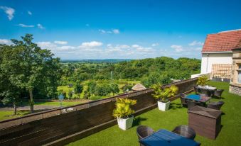 a rooftop patio with a view of the surrounding landscape , including greenery and a golf course at DoubleTree by Hilton Bristol South - Cadbury House