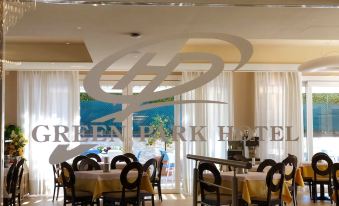 a dining room with tables and chairs set up for a meal , along with a view of the ocean at Green Park Hotel