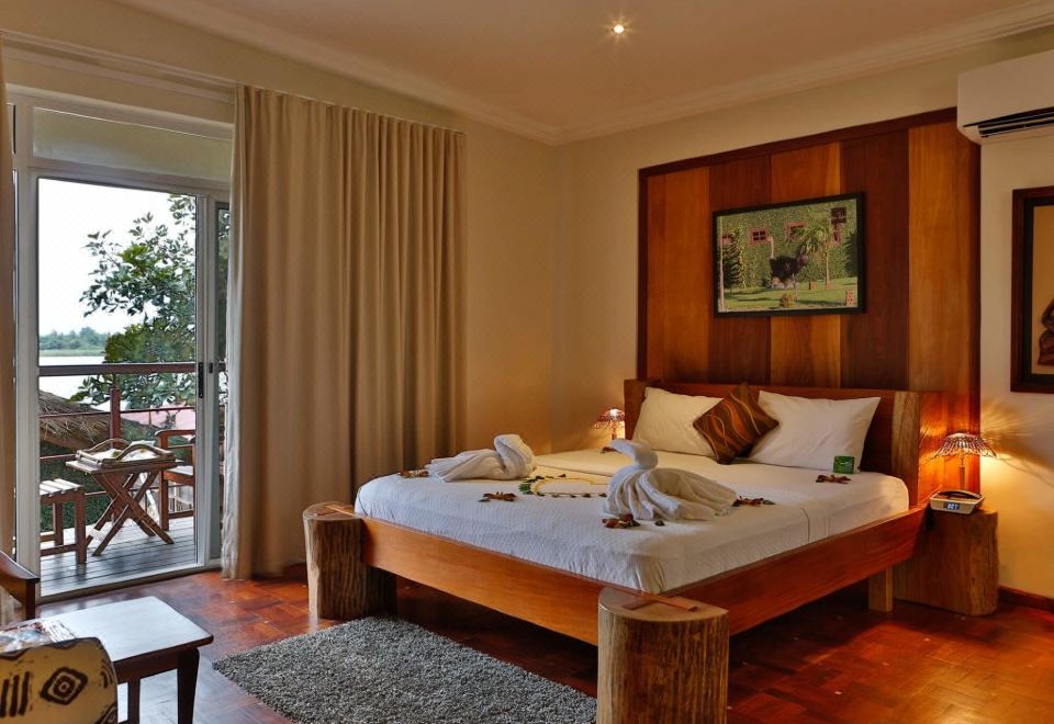 a large bed with a wooden headboard is in a room with a sliding glass door at Aqua Safari Resort