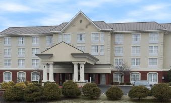 a large hotel building with multiple floors , surrounded by trees and a body of water at Country Inn & Suites by Radisson, Evansville, IN