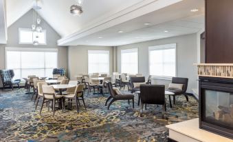 a large , open room with multiple tables and chairs arranged for a group of people to sit and eat at Residence Inn Largo Medical Center Drive