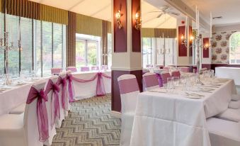 a large dining room with tables covered in white tablecloths and chairs arranged for a formal event at Best Western Moore Place Hotel