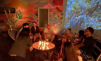 a group of people gathered around a fire pit in a room , enjoying each other 's company at The Lincoln Marfa