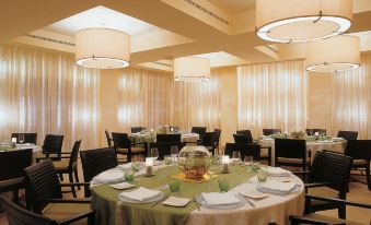 a large dining room with multiple round tables and chairs arranged for a formal event at Shangri-La le Touessrok, Mauritius