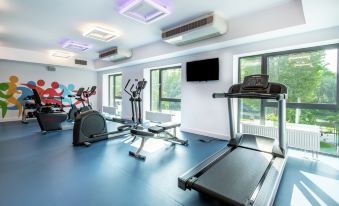 a gym with various exercise equipment , including treadmills and stationary bikes , arranged in a spacious room at Hampton by Hilton Oswiecim