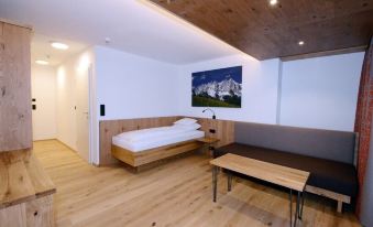 a modern bedroom with a wooden floor and white walls , featuring a bed , desk , and chair at Hotel Park