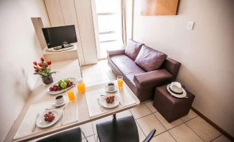 a small apartment with a dining table , chairs , and a couch in the living room at Verona Hplus Long Stay
