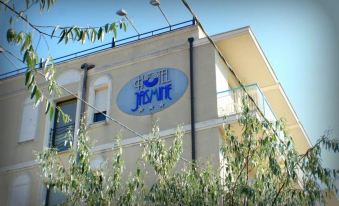 "a building with a large sign that reads "" hotel lisnot "" is surrounded by trees and bushes" at Hotel Jasmine
