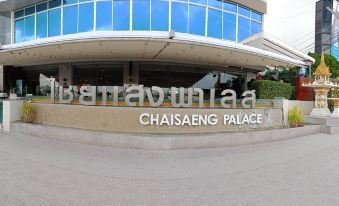 "a large building with the words "" chaisang palace "" written on it , surrounded by trees and grass" at Chaisaeng Palace Hotel