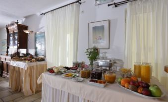 In the middle room of an upscale hotel or motel, there is a table with food on it at Brazzera Hotel