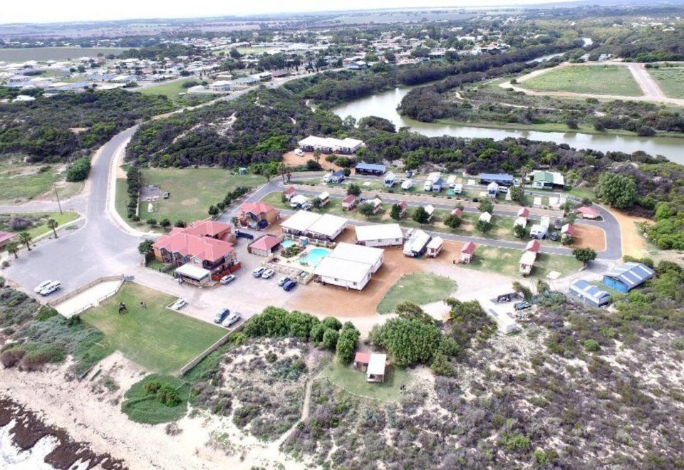 aerial view of a residential area near a body of water , with several houses and trees in the area at Seaspray Beach Holiday Park