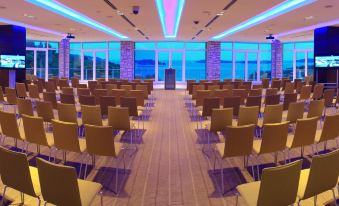 a large conference room with rows of chairs arranged in a semicircle , facing a podium at Amfora Hvar Grand Beach Resort