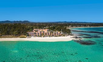aerial view of a resort on a sandy beach , surrounded by clear blue water and lush green vegetation at Salt of Palmar, Mauritius