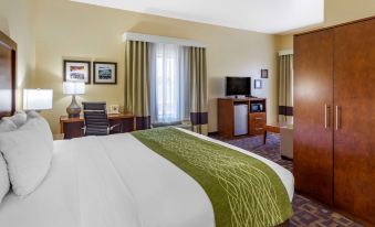 a well - appointed hotel room with a king - sized bed , a flat - screen tv , and a desk at Comfort Inn & Suites North Aurora - Naperville