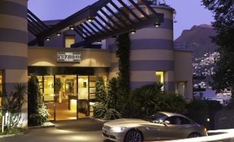 "a car is parked in front of a building with the sign "" west village "" on it" at Suitenhotel Parco Paradiso