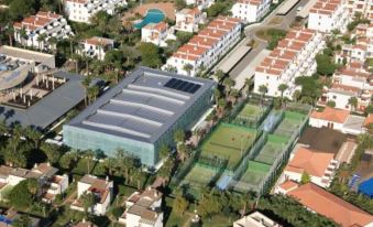 a large building with a glass roof is surrounded by white and orange houses , trees , and grass at Estival Park Silmar