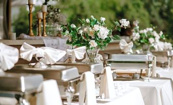 a dining table set for a formal event , with white tablecloths and multiple chairs arranged around it at Bicentennial Inn