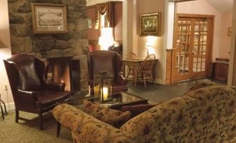 a cozy living room with a fireplace and several chairs , creating a warm and inviting atmosphere at Stroudsmoor Country Inn