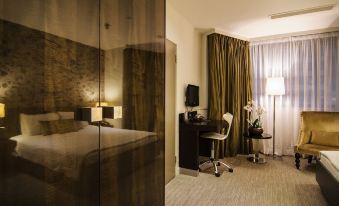 a hotel room with a bed , a desk , and a window , along with curtains and a lamp at The Hide London