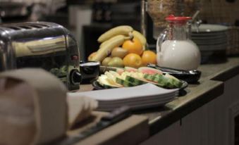 a table with a variety of food items , including fruit , bread , and a glass of milk at The Orange Tree Thornham