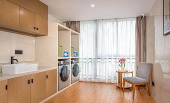 The apartment has a room with wooden floors and large windows, as well as a laundry machine at Country Inn & Suites by Radisson, Guangzhou Yonghe Branch