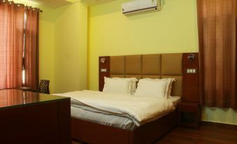 a hotel room with a large bed , white sheets , and an air conditioner on the wall at The Sojourn
