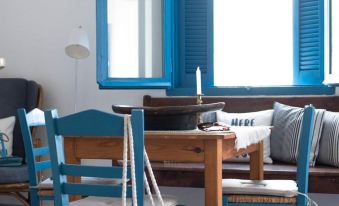 a wooden dining table with a blue chair and a bench in front of it at The White Houses