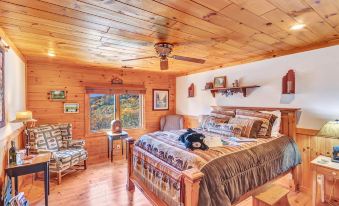 a cozy bedroom with wooden walls , a bed , and various decorations , including a dog lying on the bed at North Fork Mountain Inn