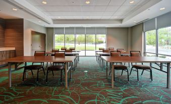 a large conference room with several chairs arranged in rows , and a green carpet covering the floor at Home2 Suites by Hilton Walpole Foxboro