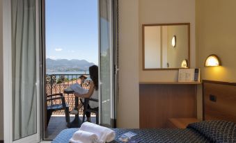 a woman is sitting on a chair in a hotel room with a view of the mountains at Hotel Boston