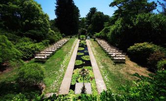 a long row of tables and chairs are set up in a grassy area with trees at The Castle at Skylands Manor