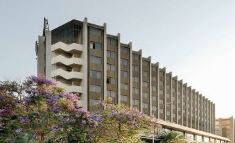 a large , modern building with a unique design and a tree in front of it at Hesperia Barcelona Sant Just