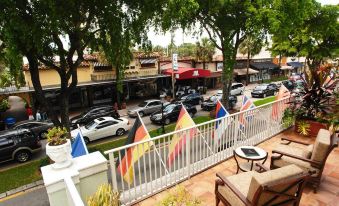 a balcony overlooking a street filled with cars and flags , with a view of the street from an elevated position at Riverside Hotel