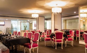 a dining room with red and white chairs arranged in rows , creating a formal atmosphere at Hotel Centre Point